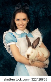 Girl Costumed As Alice In Wonderland With The White Rabbit - Portrait Of A Smiling Girl In A Blue Costume Holding A White Bunny
