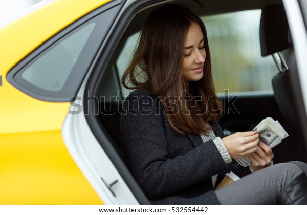 Girl counts money in
taxi