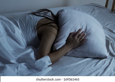 Girl covered her head with a pillow.Insomnia 