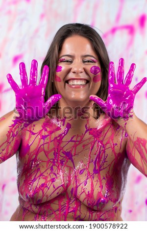 girl covered with pink paint having fun and being free, on a concept that helps against breast cancer awareness and women liberation.
