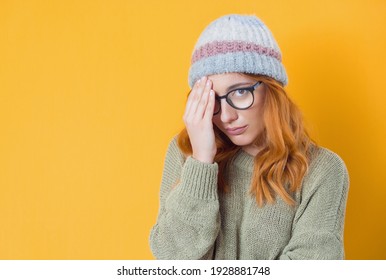 Girl covering face with hand. Shame, isolated on yellow background. Ashamed young woman. Studio shot