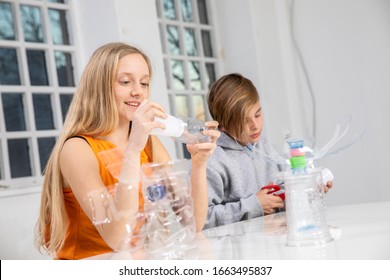 Girl creating different things from plastic bottles. You can make different kinds of things with plastic bottles, cup and other recycled material. - Shutterstock ID 1663495837