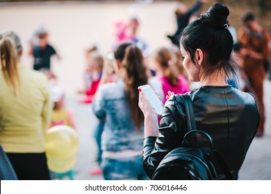 The Girl In The Crowd Uses The Phone. Street Photo