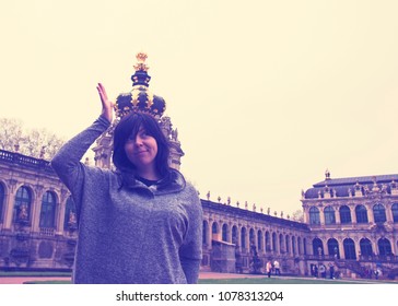 A Girl With A Crown On Her Head In Zwinger, Dresden. Forced Perspective Photography. 