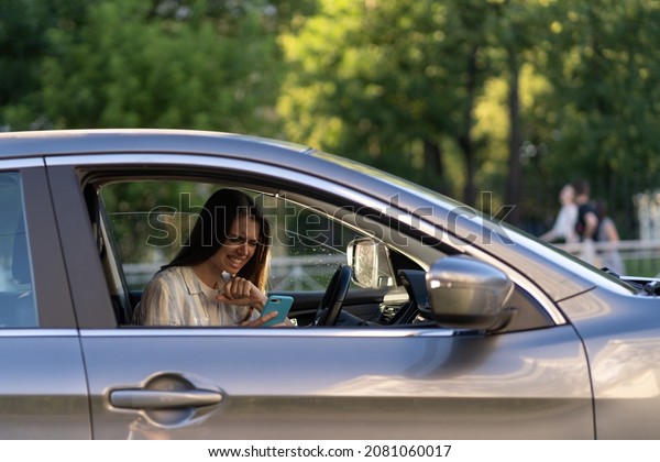 Girl cry reading message in mobile phone.\
Frustrated upset young woman in tears sit at driver seat in car\
with smartphone in hand. Female get bad news, breaking up with\
boyfriend in text sms\
messenger
