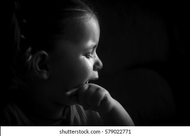 Girl crying. Baby's portrait in low key