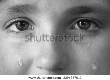 Girl crying with tears on face of cheek rolling down 