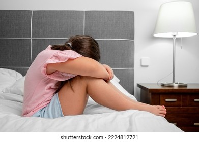 Girl Crying In Tears Sitting On Bed In Bedroom. Unhappy Children Feeling Sad Lonely And Upset In Dark Room At Night At Home. High Quality Photo