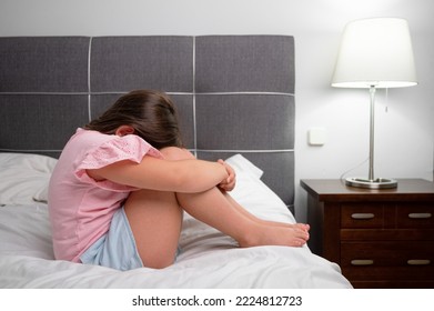 Girl Crying In Tears Sitting On Bed In Bedroom. Unhappy Children Feeling Sad Lonely And Upset In Dark Room At Night At Home. High Quality Photo