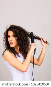 Girl With Curly Hair And Hair Straightener Worry Damage Burn  Concept  