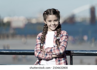 Girl cute kid with braids relaxing urban background defocused. Organize activities for teenagers. Vacation and leisure. What do on holidays. Sunny day walk. Leisure options. Free time and leisure