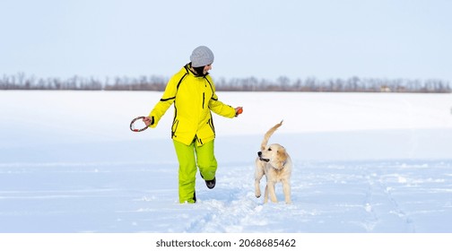 Girl With Cute Young Retriever Dog On Winter Walk