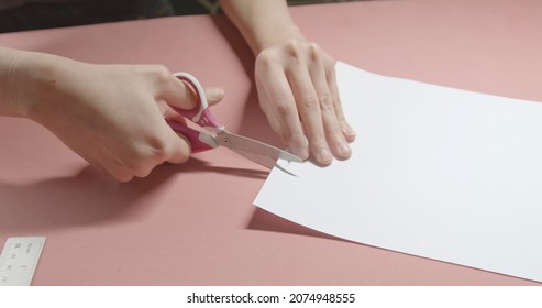 Girl Cuts Paper With Scissors