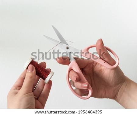 Girl cuts wire with pink scissors

