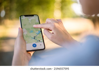 girl cyclist looks at a map on her phone and plots a route for a trip for a GPS navigator. High quality photo