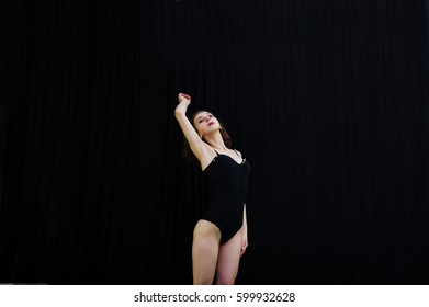 Girl dancer jumping and dancing on a black background. Studio shot of woman dancing.
