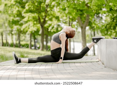 Girl Dancer Sits In Splits At Park For Warm-Up, View From Behind - Powered by Shutterstock