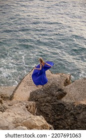 Girl Dancing By The Sea In A Blue Dress. Morning Ritual. Walk By The Sea Alone With Herself. Female Pleasure. Energy Recovery
