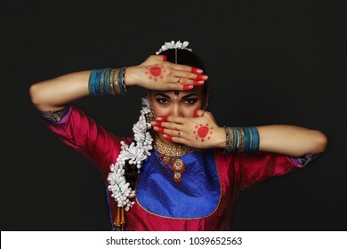 A girl is dancing an Indian dance. A dancer dances in a studio on a black background.
