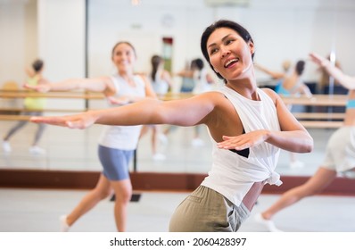  girl dancing modern dance in fitness studio with other dancers - Powered by Shutterstock