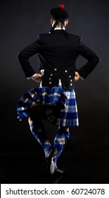 The Girl Dancing The Scottish Dance In A Kilt Sitting On A White Cube