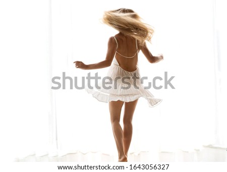 girl dancing in white light background in a white dress