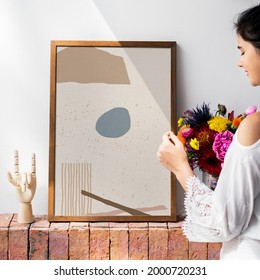 Girl decorating a wall with a frame mockup