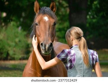 Girl in denim jacket hugging brown horse - Powered by Shutterstock