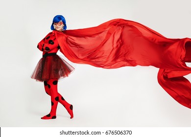 Girl with developing a red cape. Woman comic book character. Cosplay girl.