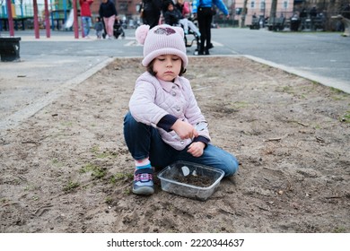 Girl Digging In The Dirt On The Playground On A Foggy Fall Day