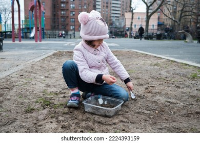 Girl Digging In The Dirt On The Playground On A Foggy Fall Day