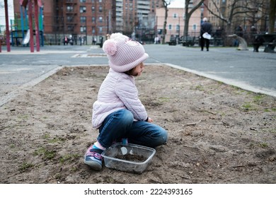 Girl Digging In The Dirt On The Playground On A Foggy Fall Day