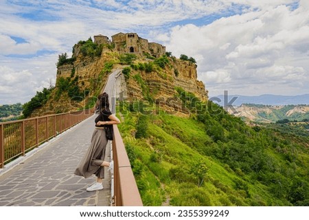 Girl with the disappearing village behind her, Civita di Bagnoregio