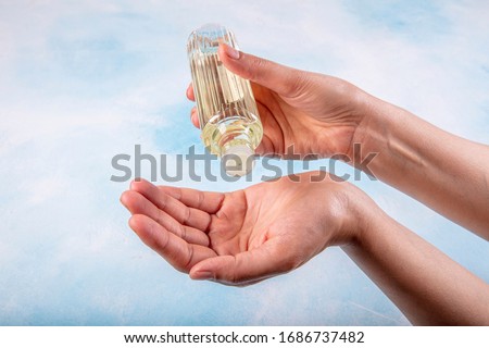 Girl disinfecting hands with cologne. Turkish Lemon cologne with 80 degree alcohol for disinfection and killing the viruses on your hands.