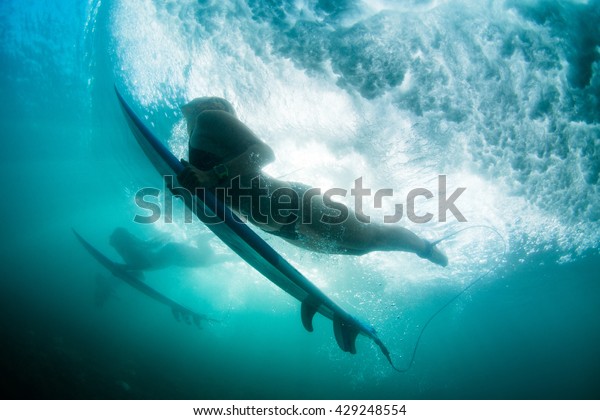the girl dives under a\
wave. duck dive