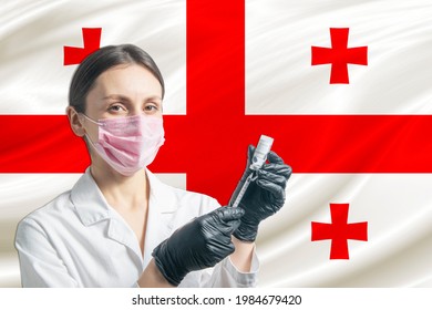 Girl doctor prepares vaccination against the background of the Georgia flag. Vaccination concept Georgia.