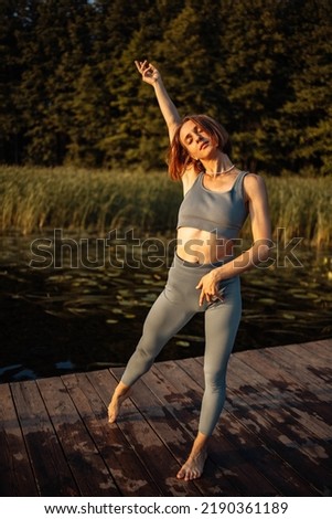 A girl does yoga at sunset