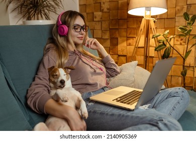 A Girl With A Dog Watching A Movie On A Laptop With Headphones. Pets And Pet Friends For People