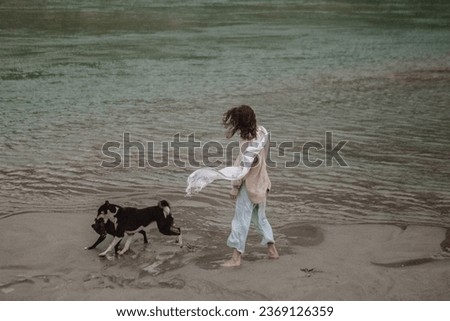 A girl with dogs on the banks of the Ganges River in India