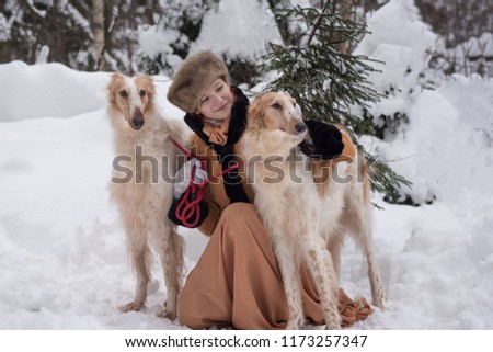 girl with dogs in the winter in the forest