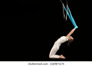 Girl doing aero stretching. Sport girl practicing fly yoga in hammock. Athletic woman doing aero gravity yoga exercises