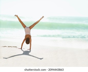 Girl Doing Cartwheel On Beach
