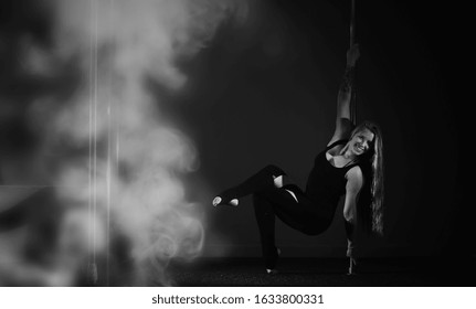 Girl doing exercises on a sports equipment. The dancer on the pylon in the studio. - Shutterstock ID 1633800331