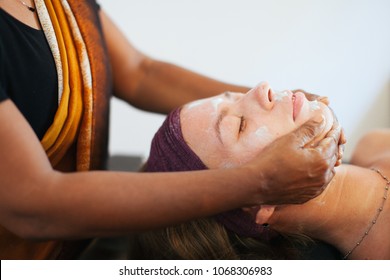 The Girl Doing The Facial Massage . The Cream On The Face. Ayurvedic Treatment. Spa Treatments In Asia. Ayurveda Salon
