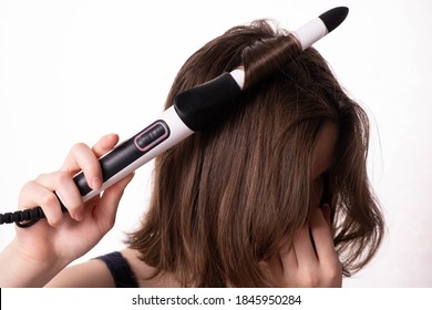 girl doing her hair, curls with a hot curling iron