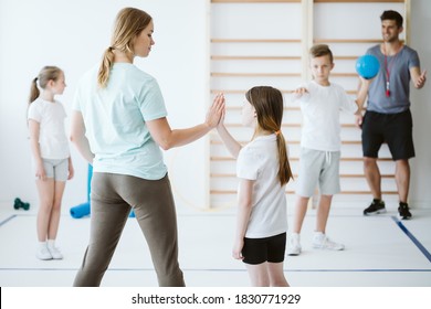 Girl Doing High Five With Her Teacher During Physical Education At School