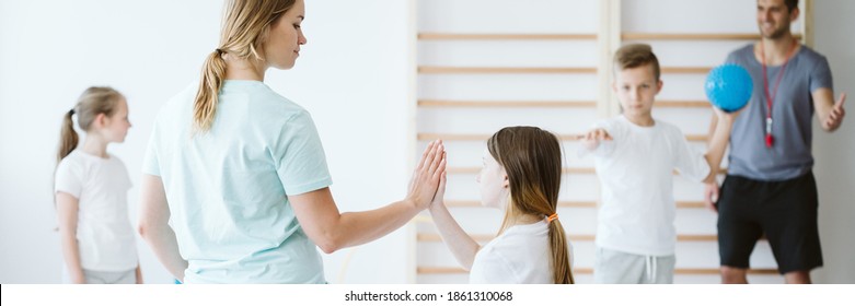 Girl Doing High Five With Her Teacher During Physical Education At School