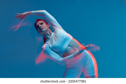 Girl Doing Side Tilt. Isolated Sport Figure Of A Young Woman Exercising In White Suit On Blue Background. Neon Photo With Motion Blur Effect.