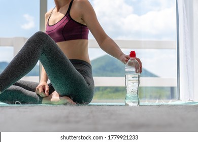 Girl Doing Sports Fitness At Home Resting And Taking Bottle With Water