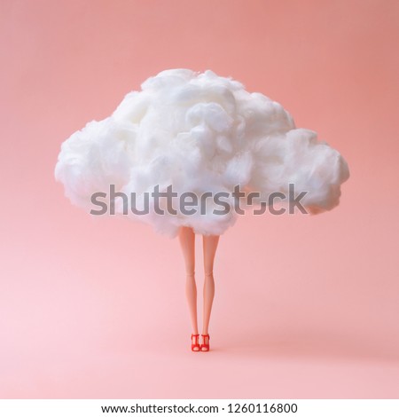 Girl doll against pastel coral color background. Head in the clouds concept.